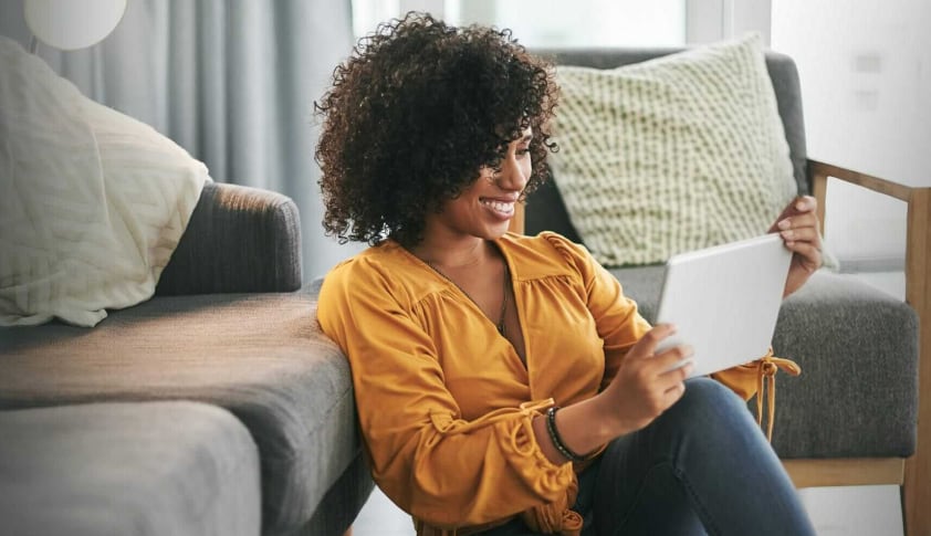 Woman sitting in her living room looking at an iPad